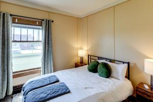 リンカーンにある1 Mi to UNL Group Getaway with Game Areaの枕が2つ付いたベッドと窓のある寝室