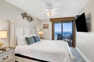 a bedroom with a bed and a balcony with the ocean at Phoenix II 2062 in Romar Beach
