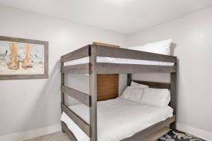 a bedroom with a bunk bed with white sheets at Phoenix II 2062 in Romar Beach