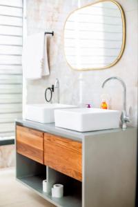 a bathroom with a sink and a mirror at Résidences Millenium Suites Yakro in Yamussukro