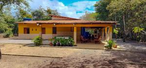 a small yellow house with a porch at Sítio Wida Feliz in Crato