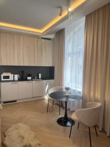 a living room with a table and chairs and a kitchen at Apartamenty Beauty & SPA in Ełk