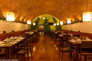 a dining room with tables and chairs and lights at Bohol Sunside Resort in Panglao