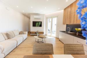 a living room with a white couch and a kitchen at Luxury Seaside Escape - Coralia in Marina San Vito