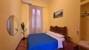 Un dormitorio con una cama azul y un espejo. en VENTO di MARE, en Palermo