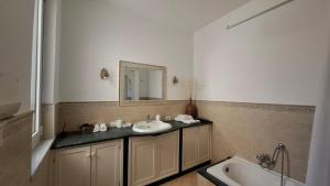 Un baño con lavabo, bañera y espejo. en VENTO di MARE, en Palermo