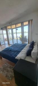 a bedroom with a bed with blue sheets and a view of the ocean at Sobe i apartmani "Terasa" in Smederevo +39 photos