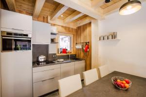 eine Küche mit weißen Schränken und einem Tisch mit einer Schale Obst in der Unterkunft Simply Morzine - Chalet Petit Central in Morzine