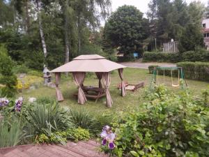a garden with a gazebo and a swing at Leśne Zacisze in Kretowiny