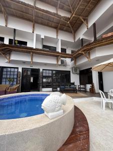 a swimming pool in a building with a patio and a table at Hostal Brisas del Mar in Punta Negra