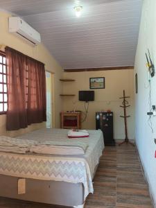 a bedroom with a bed and a tv in it at Casa Estrela Matutina Rural in Pirenópolis +9 photos