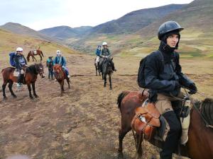 a group of people riding horses in a field at Sani Lodge & Cottages in Sani Pass