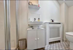 a white bathroom with a sink and a toilet at Stylish apartment in Portstewart in Moffat +2 photos