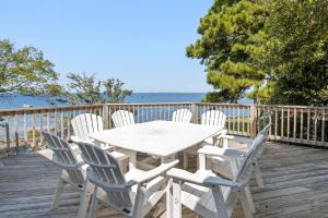 a white table and chairs on a deck with the ocean at Animal House in Corolla
