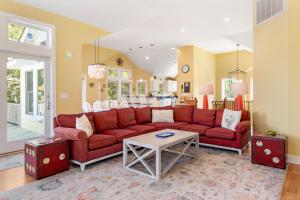 a living room with a red couch and a table at Animal House in Corolla