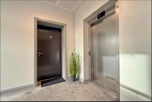 a hallway with a door and a potted plant at Stylish apartment in Portstewart in Moffat