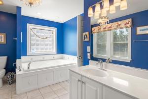 a blue bathroom with a tub and a sink at Animal House in Corolla +71 photos