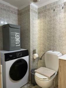 baño con TV en la parte superior de una lavadora en The Cozy Central Home, en Xanthi 9 fotos más