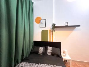 una camera con letto e tenda verde di Amour Room For Couple in Barsha Heights Tecom a Sabkhah