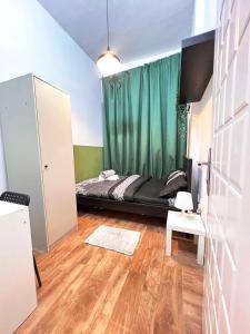 una camera con letto e tenda verde di Amour Room For Couple in Barsha Heights Tecom a Sabkhah