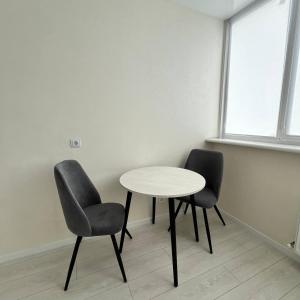 a table and two chairs in a room at A cozy and bright studio apartment in Chornomorsk