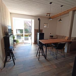 a kitchen and dining room with a wooden table and chairs at Gite du lavoir in Sirod