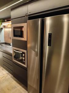 una cucina con frigorifero in acciaio inox e forno a microonde di Flatpremium1501 a Fortaleza Altre 14 foto