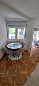 a living room with a table and chairs in it at Apartman OZ II in Bihać