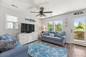 a living room with two couches and a flat screen tv at Aqua Adventure in Kill Devil Hills