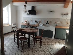 a kitchen with a table and chairs in it at Le Balcon d'Arcyate in Arcy-sur-Cure