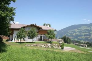 a house on a hill with a green lawn at Appartements Rosmarie Hollaus in Fügenberg