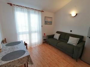 a living room with a green couch and a table at Apartman Dide in Igrane