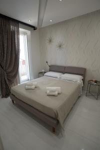 una camera da letto con un letto grande con due asciugamani sopra di Dimora Santi e Marinai a Bari