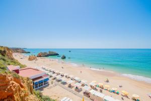 a beach with umbrellas and people on the beach at Casa Ocean Breeze, Two bedrooms, 100m from the beach! in Portimão