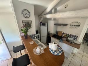 a kitchen with a table and a clock on the wall at Auvergne, Aventure in Trézioux