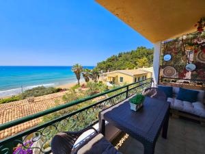 a balcony with a table and chairs and the beach at Corfu Glyfada Beach Apartment 25 in Glyfada