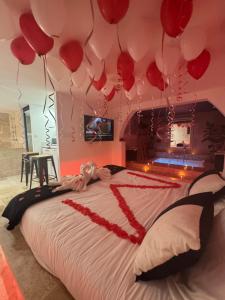 a bedroom with red balloons hanging above a bed at Suite Prestige in Codolet