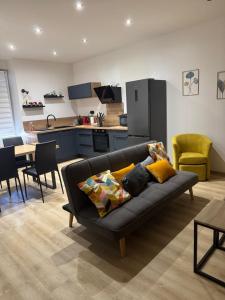 a living room with a couch and a kitchen at Appartement VERDUN-Faubourg in Verdun-sur-Meuse