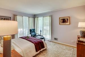 普林斯顿1 Mi to Campus Princeton Home with Furnished Deck的一间卧室，里面有一张床、一把椅子和一扇窗户