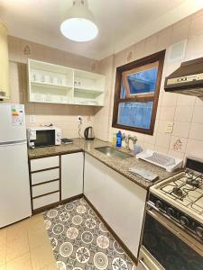 a small kitchen with a sink and a microwave at Marcelinos la perla in Mar del Plata