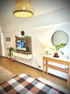 a living room with a television and a mirror at Marcelinos la perla in Mar del Plata