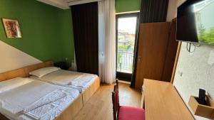 a bedroom with a bed and a tv and a window at Villa Enhalon in Struga