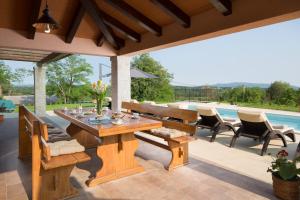 eine Terrasse mit Tisch und Stühlen und einem Pool in der Unterkunft Villa San Martino With Heated Pool , Outside Jacuzzi & Hydromassage bathub in Nedeščina