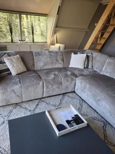 sala de estar con sofá y mesa con un libro en bungalow 199 durbuy, en Durbuy