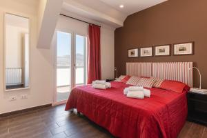 a bedroom with a red bed with two pillows on it at Marbela Apartments & Suites in Palermo