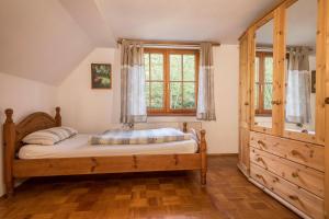 a bedroom with a wooden bed and a window at Ferienwohnung Achraintal 1 in Lindau