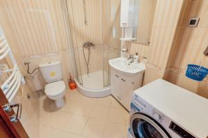 a bathroom with a shower toilet and a washing machine at Apartmani Jelena in Tivat +46 photos