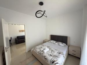 Un dormitorio con una cama y una habitación con un espejo. en Rei Apartments 3, en Lezhë