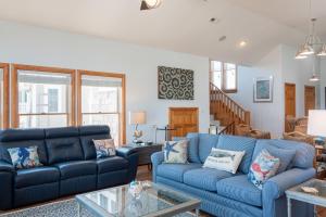 ein Wohnzimmer mit blauen Sofas und einem Tisch in der Unterkunft Blue Moon in Nags Head