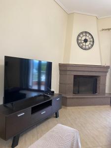 a living room with a large television and a fireplace at Sunies Home in Soúrpi